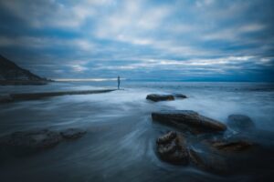 Person ser ud over havet i morgengryet