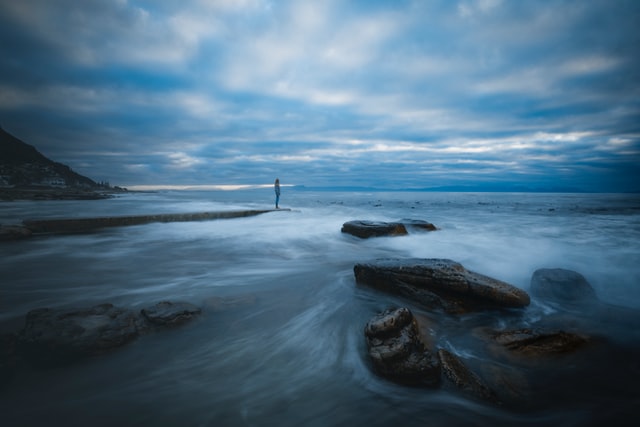 Person ser ud over havet i morgengryet